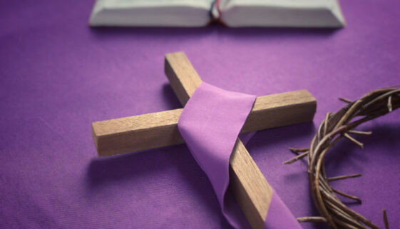 Good Friday, Lent Season and Holy Week concept - A religious cross, a bible and a woven crown of thorns on purple background.